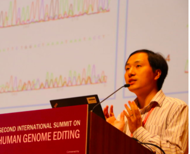 A man stands at a podium labeled Second International Summit on Human Genome Editing. Scientific data appear on a screen behind him.