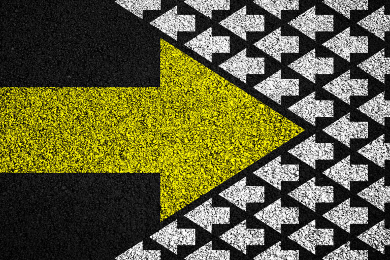 A large, right-pointing yellow arrow opposing a flock of small, left-pointing white arrows.