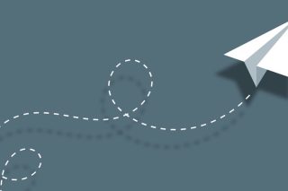 A paper airplane on a blue/green background, trailing a white dotted line.