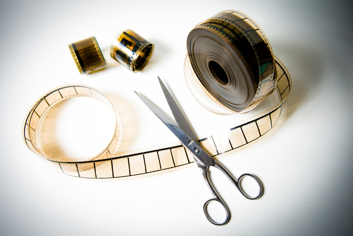 A film reel being cut with scissors.