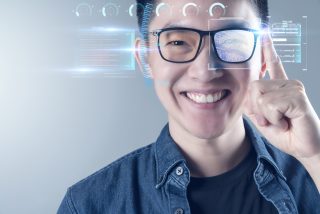 A smiling person wearing smart glasses.