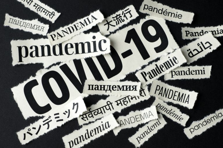 Scraps of newspaper headlines relating to the Covid-19 pandemic, in multiple languages