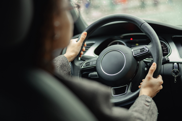 A person's hands on the steering wheel of a car.