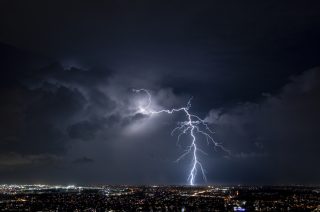 A bolt of lightning strikes in a night sky.