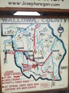 A photograph of a large map of Wallowa County, Oregon, showing roads, wildlife, and bodies of water.