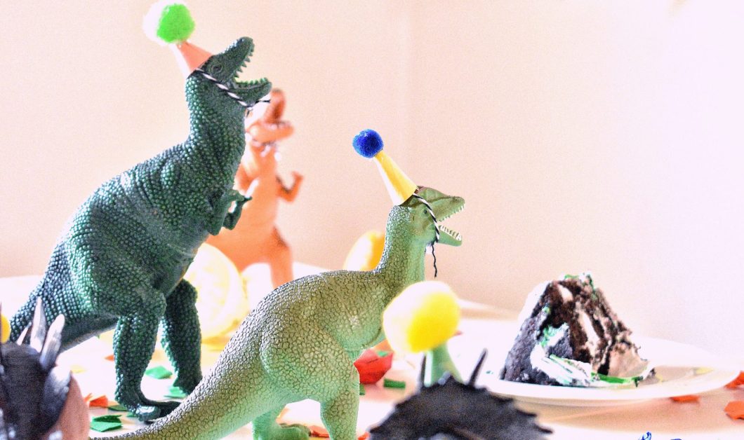 A birthday party with dinosaurs wearing birthday hats, which is ridiculous.