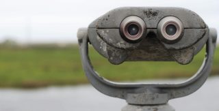 An outdoor binocular viewer with an indistinct landscape in the distance.