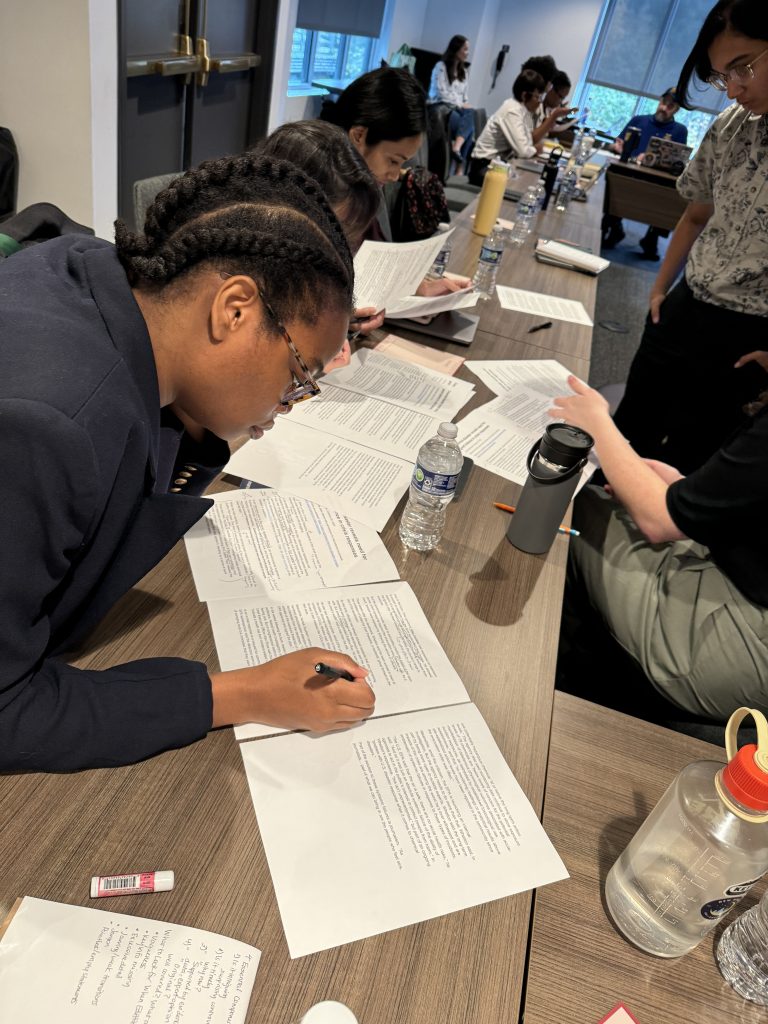 Participants in a writing workshop working at a conference table.
