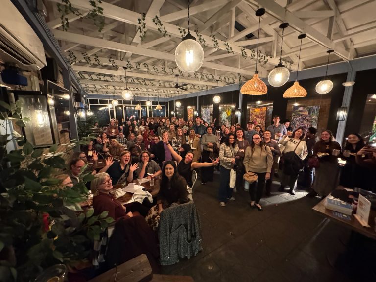 A smiling crowd in an indoor event space.