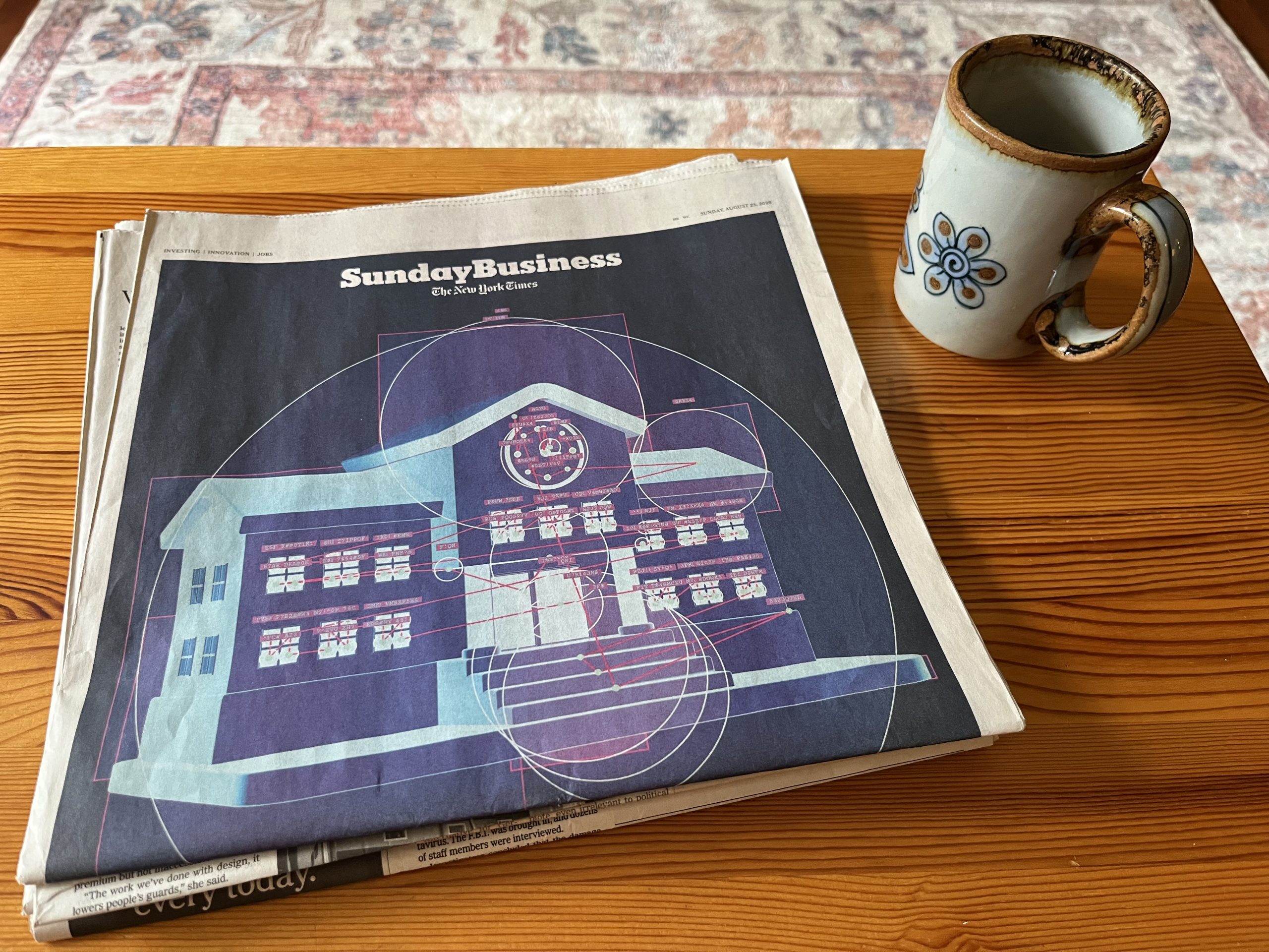 A Sunday edition of the New York Times on a coffee table next to a coffee mug